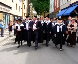 Oxford students exploring the city in their gowns. This shows the happy people in the city.