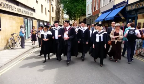 Oxford students exploring the city in their gowns. This shows the happy people in the city.