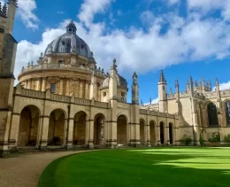 The stunning buildings of an Oxford college. The arches, vaults, and spires of this college are visible in the sunlight. These architectural joys and more can be seen on the private walking tour of Oxford with Chris Peters.