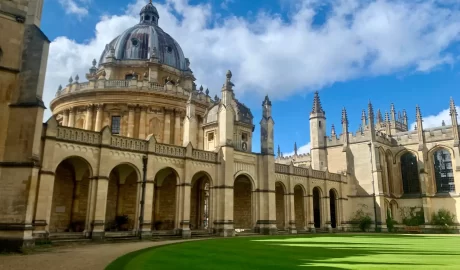 The stunning buildings of an Oxford college. The arches, vaults, and spires of this college are visible in the sunlight. These architectural joys and more can be seen on the private walking tour of Oxford with Chris Peters.