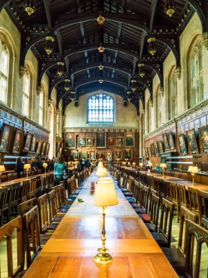 The hall at University College Oxford where there is a private walking tour taking place. The hall is lined by artwork and paintings.